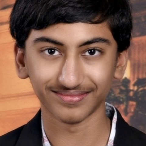 Headshot of Akhil Krishnan from the shoulders up smiling in a suit jacket.